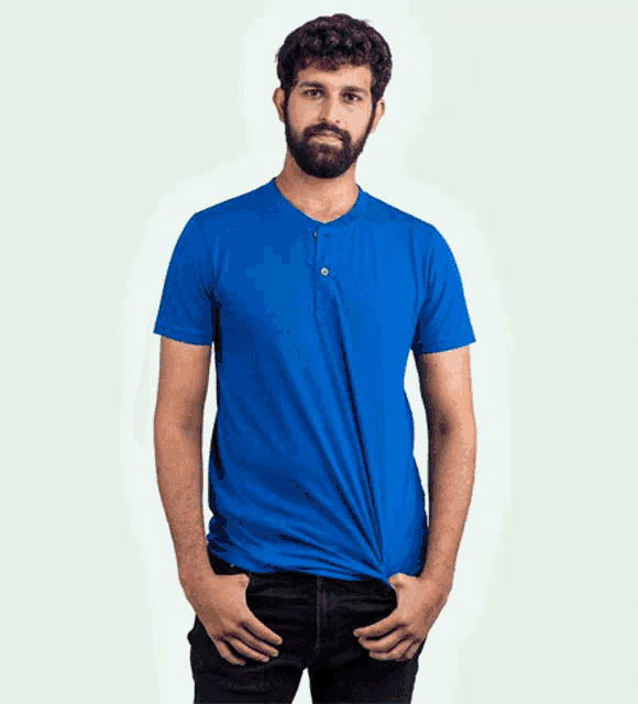 a man in a blue polo shirt is adjusting his sleeves