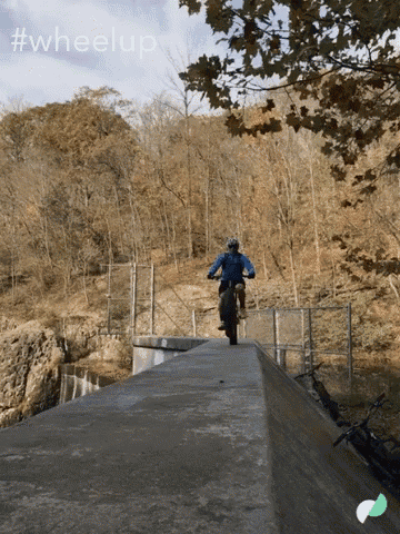 a person riding a bike down a ramp with #wheelup written in the background