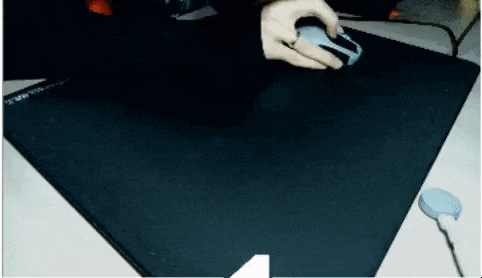 a person is using a computer mouse on a black mat
