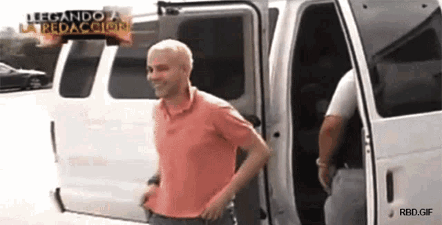 a man in a pink shirt is getting out of a white van with the words llegando a la redaccion on the bottom