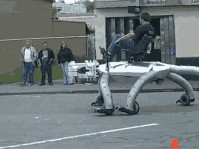 a man in a black shirt is sitting in a chair on a machine that looks like an octopus .