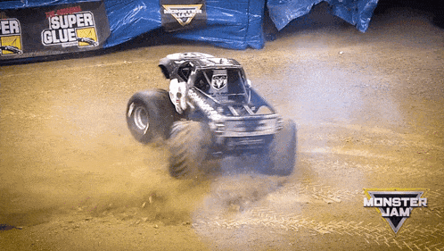 a monster jam truck is driving down a dirt road