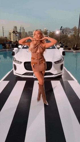 a woman in a brown dress is standing in front of a car