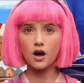 a woman with pink hair is making a surprised face .
