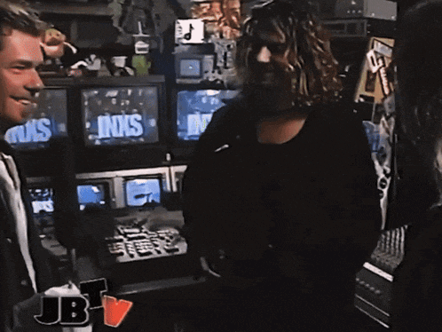 two men are standing in front of a screen that says inxs on it