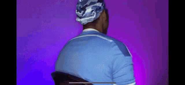 a man with his arms crossed is on a purple background with a fireball in the background .