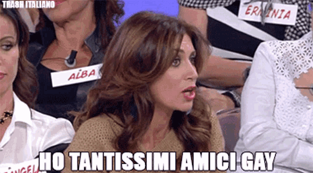 a woman sitting in a crowd with the words ho tantissimi amici gay
