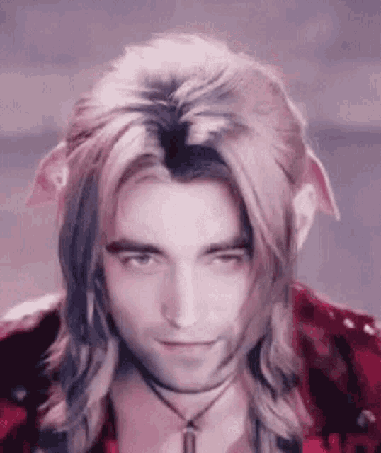 a close up of a man with long hair wearing a red jacket and a choker .