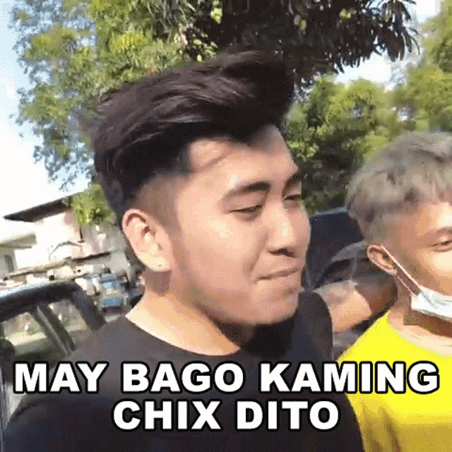 a man wearing a mask is standing next to another man and says may bago kaming chix dito .