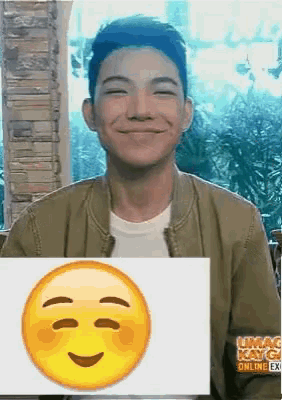a man is smiling while holding a sign that says umag kay gi online ex