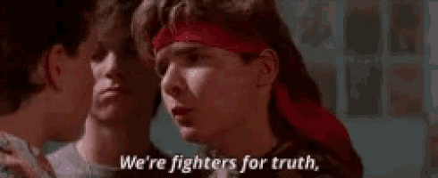 a man wearing a red headband is talking to another man .