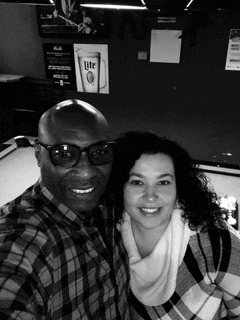 a man and a woman are posing for a selfie in front of a miller lite sign