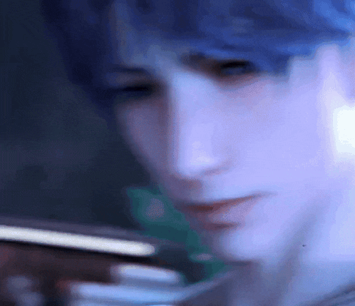 a close up of a man 's face with blue hair looking at something