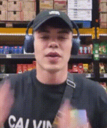 a man wearing headphones and a calvin klein shirt is standing in a store