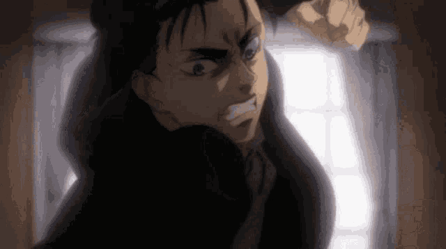 a man in a black coat is standing in front of a window and making a funny face .