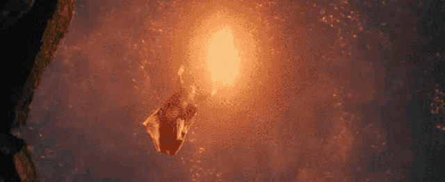 a person is flying through the air in front of a glowing light