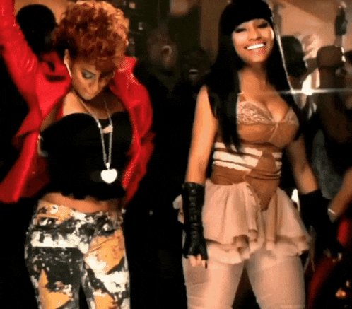 two women are dancing and one has a heart necklace on her neck
