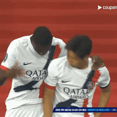two soccer players wearing qatar airways jerseys on a red field