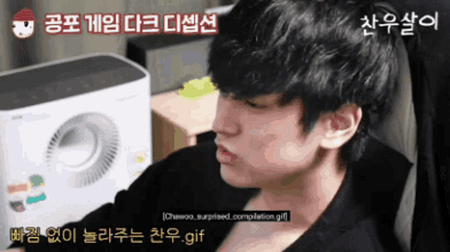 a man is sitting in front of a fan with chinese writing on the bottom