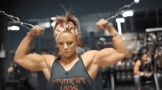 a woman in a tank top that says primeval abs is lifting weights