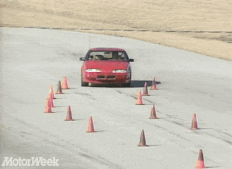 a red car is driving down a road with motorweek written on the bottom right