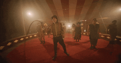 a man in a top hat stands in the middle of a circus