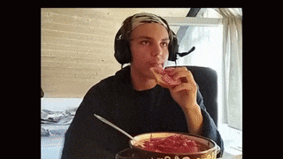 a man wearing headphones is eating a piece of meat from a bowl
