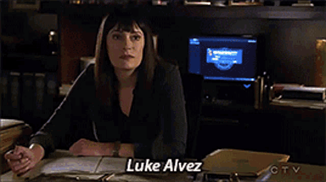 a man in a black shirt is holding a bag and says luke alvez on the bottom