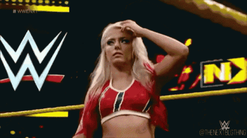 a woman in a wrestling ring with a wwe logo behind her