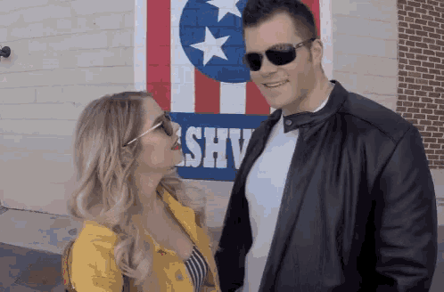 a man and woman are kissing in front of a sign that says shy
