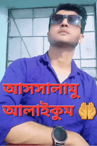 a man wearing sunglasses and a blue shirt has a sticker on his shirt that says ' assalamu '