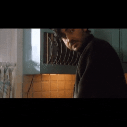 a man is standing in a kitchen with a sign that says ' shannon ' on the bottom