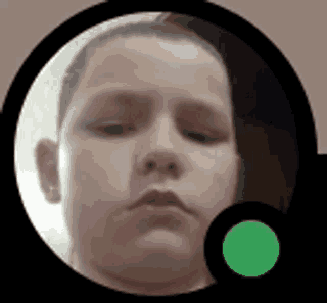 a close up of a child 's face in a circle with a green circle in the middle
