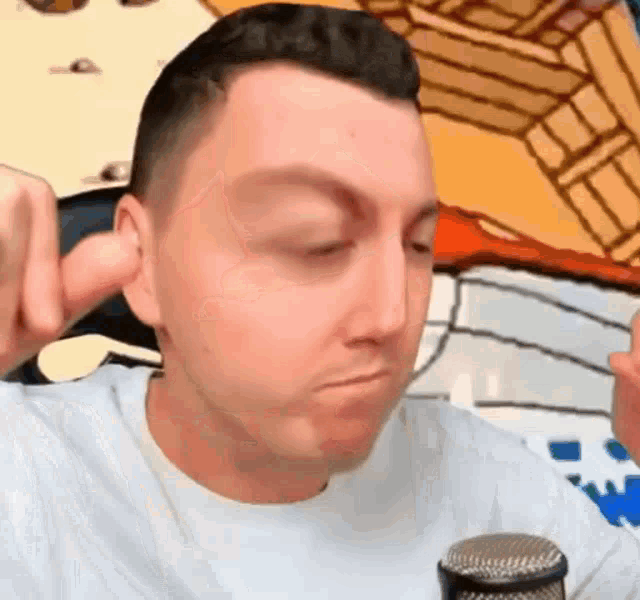 a man is making a face in front of a microphone .