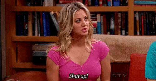 a woman in a pink shirt is sitting on a couch talking to a man and says `` shut up '' .
