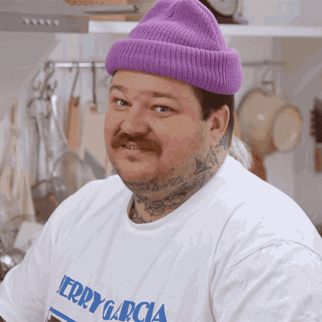 a man wearing a purple beanie and a white shirt that says jerry garcia