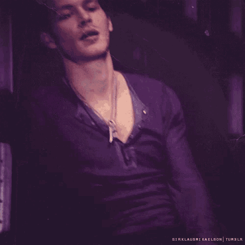 a man wearing a purple shirt and a necklace with the words sirklausmi kaelson tumblr on the bottom right