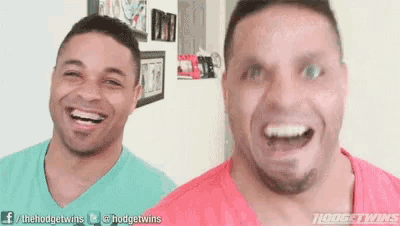 two men are laughing and looking at the camera while standing next to each other .