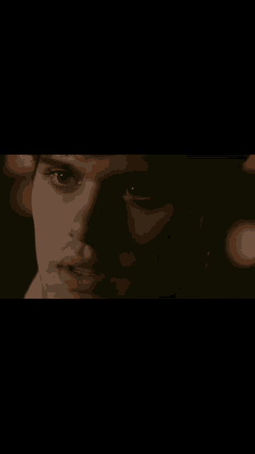 a close up of a man 's face in the dark .