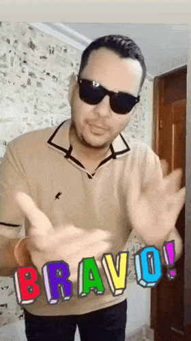 a man wearing sunglasses and a tan shirt says bravo