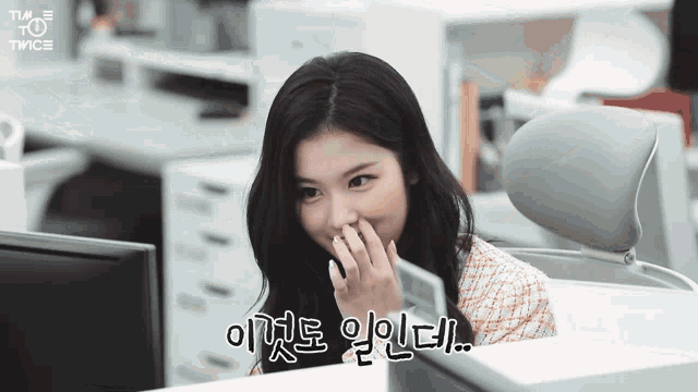 a woman sitting in front of a computer with twice written on the bottom left