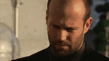 a bald man with a beard is wearing a suit