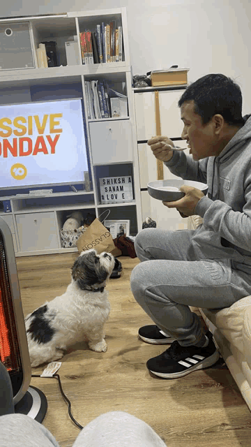a man eating a bowl of food in front of a tv screen that says ' ssive sunday ' on it