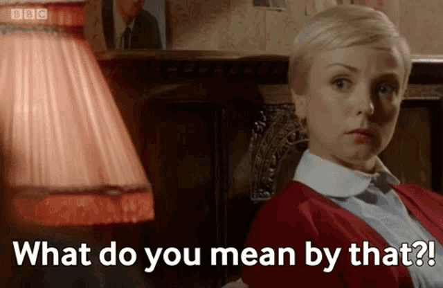 a woman is sitting in front of a lamp and says what do you mean by that