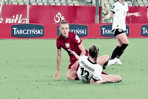 a soccer player with the number 12 on her jersey is laying on the ground