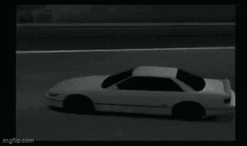 a white car is driving on a race track in a video game .