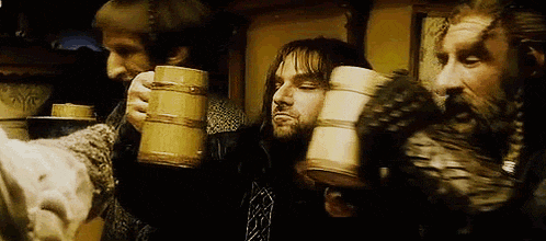 a group of men are drinking from wooden mugs in a room .