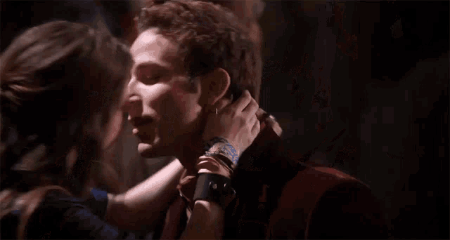 a man and a woman are kissing in the dark
