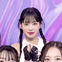 a group of girls are posing for a picture together . one of the girls is wearing gloves .
