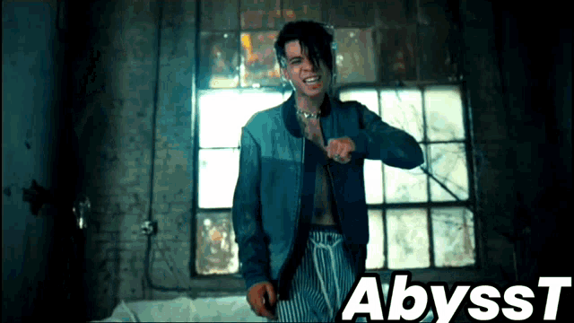 a man in a blue jacket is standing in front of a window with the word abyss t on the bottom